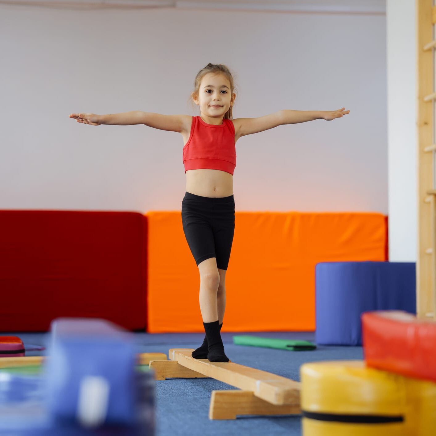 Happy girl during corrective gymnastics Cute active child girl in sensory integration room, kindergarten. Kid is active leisure. Childhood and sporty lifestyle.Sports weekend in gymnastic center. Fitness,healthy, develop skills concept